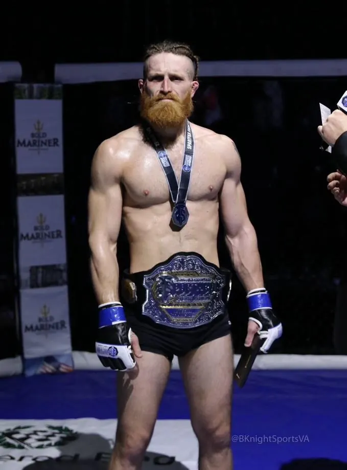 Chris Simpson wearing his championship belt and medal