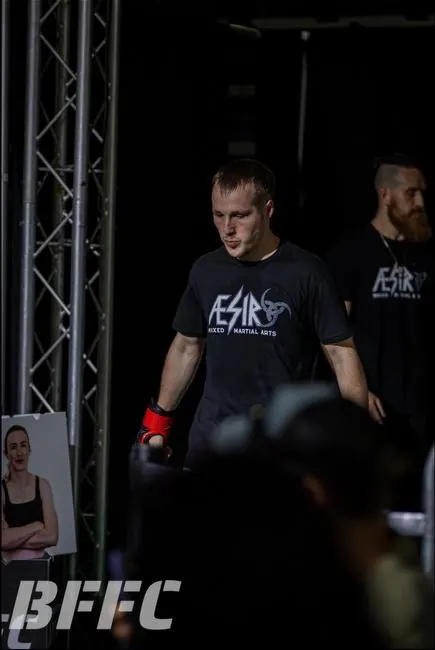 Aesir fighter and coach walking out to the cage